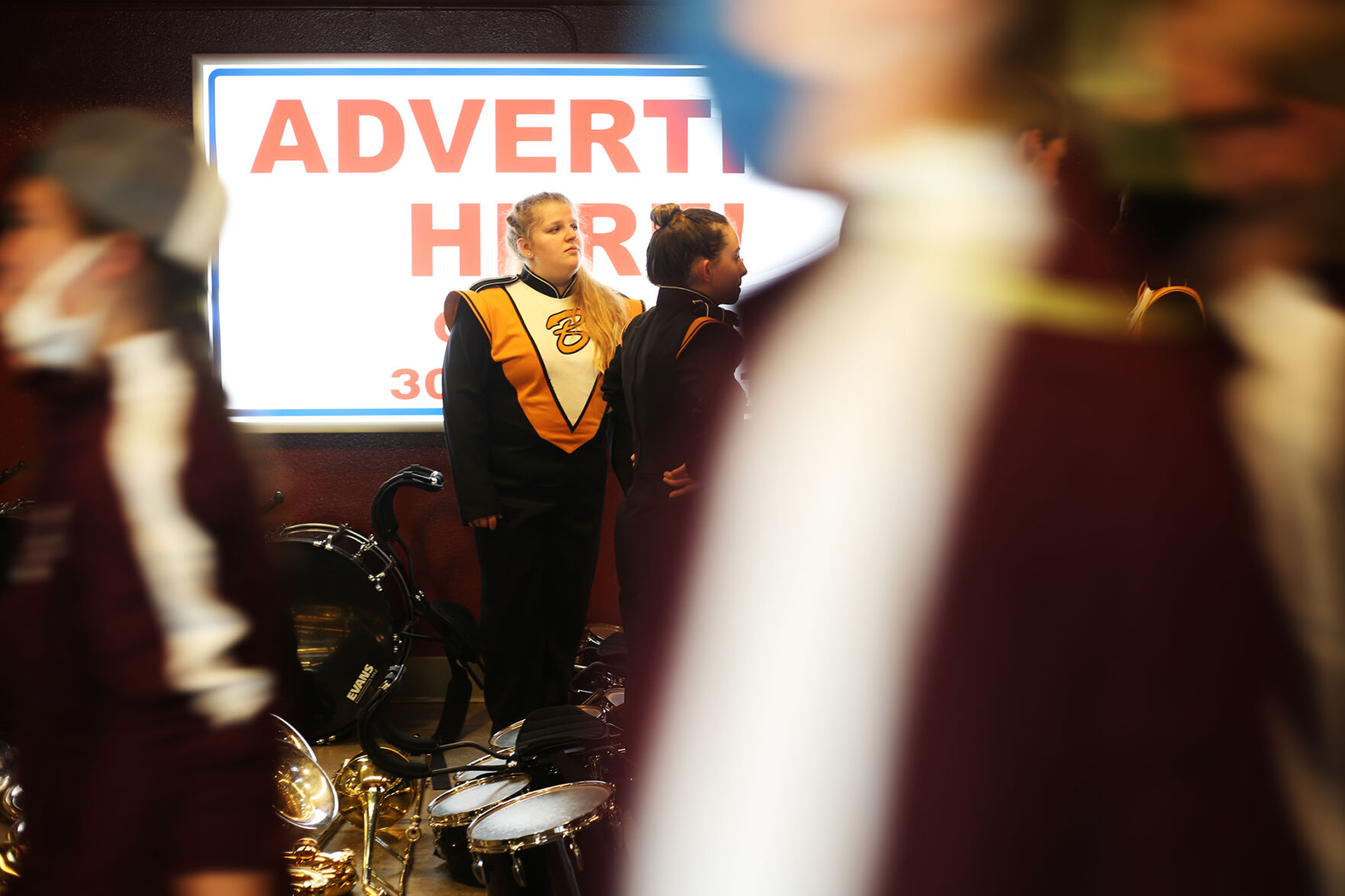 Olivia Rhoads stands in the middle of the BHS instrument pile as other bands pass by during an intermission